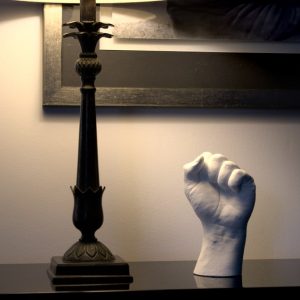 sculpture d'une main en plâtre blanc posée sur un meuble