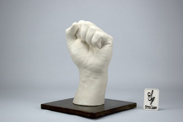 sculpture d'une main en plâtre blanc et son socle en acier