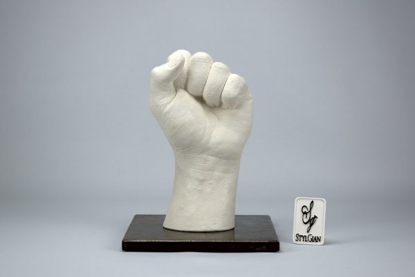 sculpture d'une main en plâtre blanc et son socle en acier